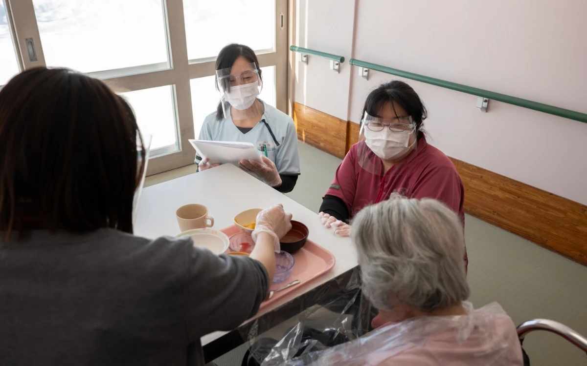 食事する利用者の様子を見守る岩渕さん